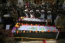 Shiite clerics and mourners pray over the Iraqi flag-draped coffins of two people killed in protests at Baghdad's highly fortified Green Zone on Friday, during their funeral at the holy shrine of Imam Ali, in Najaf, 100 miles (160 kilometers) south of Baghdad, Iraq, Saturday, May 21, 2016. Hundreds gathered in Baghdad's Sadr City and at the holy shrine of Imam Ali in Najaf, as families held funerals for the two men killed in Friday's protests. Their coffins were hoisted above the crowds of mourners in Sadr City before being driven to Najaf for burial. (AP Photo/Anmar Khalil)
