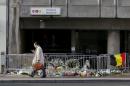 A man walks past a street memorial outside Maelbeek metro station, a week after bomb attacks took place in the metro and at the Belgian international airport of Zaventem, in Brussels, Belgium
