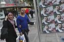 Iranians walk past posters of the presidential candidate Mohsen Rezaei, a former Revolutionary Guard commander, a day prior to the election, in Tehran, Iran, Thursday, June 13, 2013. (AP Photo/Vahid Salemi)