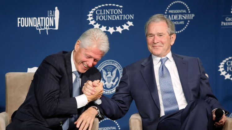 Former presidents Bill Clinton (L) and George W. Bush (R) shake hands and joke on stage during a Presidential Leadership Scholars program event at the Newseum in Washington September 8, 2014.
