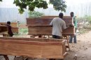 Men craft coffins for some of the more than 200 people killed by explosions at a munitions depot, in Brazzaville, Congo Thursday, March 8, 2012. Many of the at least 246 victims of last weekend's deadly arms depot blasts in the Republic of Congo's capital will be buried Sunday in a mass funeral, state radio reported Thursday. (AP Photo)
