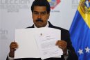 Venezuela's President-elect Nicolas Maduro holds the certificate from the CNE as winner of Sunday's election in Caracas