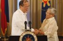 Philippine President Aquino shakes hands with Presidential Adviser on the Peace Process, Secretary Quintos-Deles after his speech on national television at the Malacanang palace in Manila