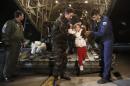 A man and his daughter, rescued from Norman Atlantic ferry, disembark from Greek Airforce C-130 military cargo aircraft at Elefsina military airport near Athens