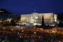 Demonstrators stand during a protest in front of the parliament in Athens