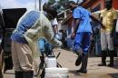 A health worker sprays a colleague's boots with chlorine disinfectant in Monrovia