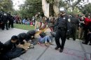 A University of California Davis police officer pepper-sprays students during their sit-in at an "Occupy UCD" demonstration in Davis