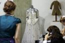 A 1986 Emanuel ball gown worn by late Princess Diana is displayed on a mannequin during an auction in London, Tuesday, Dec. 3, 2013. According to the auction house, Diana wore the gown with gold sequins, crystals and pearl beads comes with matching headband, optional sleeve panels and petticoat, in various occasions. (AP Photo/Lefteris Pitarakis)