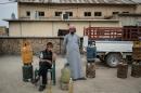 In this April 9, 2016 photo, a man and boy sell gas cylinders in central Rabia, northwestern Iraq. When Iraqi Kurdish forces retook Rabia last year it was a major advance against the Islamic State group, which had swept across northern and western Iraq in the summer of 2014 and declared its caliphate across its territory in Iraq and Syria. Now 18 months later, the town demonstrates the difficulties of returning to the way things were before the IS rampage. (AP Photo/Alice Martins)