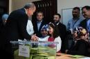 Turkish President Recep Tayyip Erdogan (L) shakes hands with a girl after voting in Turkey's general election at a polling station in Istanbul on June 7, 2015