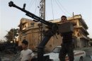 A Free Syrian Army member stands by his anti-aircraft machine gun during their patrol in Attarib, on the outskirts of Aleppo province