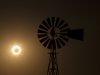 The moon passes between the sun and the earth behind a windmill near Albuquerque, New Mexico
