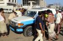 Yemenis look at a police vehicle after gunmen opened fire on it killing two policemen, on March 5, 2016 in the main southern city of Aden
