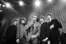 CORRECTS DATE OF PHOTO TO FEB. 8, 1964, INSTEAD OF FEB. 9, 1964 - FILE - In this Feb. 8, 1964 file photo, Ed Sullivan, center, stands with The Beatles, from left, Ringo Starr, George Harrison, John Lennon, and Paul McCartney, during a rehearsal for the British group's first American appearance, on the "Ed Sullivan Show," in New York. The Beatles made their first appearance on "The Ed Sullivan Show," America's must-see weekly variety show, on Sunday, Feb. 9, 1964. And officially kicked off Beatlemania. (AP Photo/File)