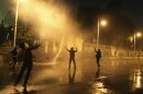 Protesters opposing Egyptian President Mohamed Mursi and the Muslim Brotherhood chant anti-government slogans while police spray water on them from inside the Presidential Palace, in Cairo