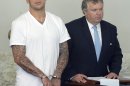 FILE - In this June 26, 2013 file photo, former New England Patriots tight end Aaron Hernandez, left, stands with his attorney Michael Fee, right, during arraignment in Attleboro District Court in Attleboro, Mass. A police search of a secret "flop house" rented by Hernandez turned up boxes of ammunition and clothing police believe could be evidence in the murder case against him, according to court documents. (AP Photo/The Sun Chronicle, Mike George, Pool, File)
