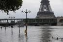 Road signs emerge on the banks of the Seine river next to the Bir Hakeim bridge and the Eiffel Tower during floods in Paris, Saturday June 4, 2016. The level of the Seine started to drop after peaking earlier in the morning. Both the Louvre and Orsay museums were closed as officials said the Seine had been at its highest level in nearly 35 years. (AP Photo/Francois Mori)