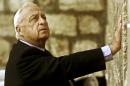 FILE - In this Wednesday Feb. 7, 2001 file photo, Ariel Sharon, then Israel's Prime Minister-elect, looks up as he touches Judaism holiest site, the Western Wall, in Jerusalem. The son of former Israeli Prime Minister Ariel Sharon says his father has died on Saturday, Jan. 11, 2014. The 85-year-old Sharon had been in a coma since a debilitating stroke eight years ago. His son Gilad Sharon said: "He has gone. He went when he decided to go." (AP Photo/David Guttenfelder, File)