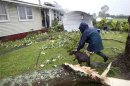 A woman returns a lost dog to its ruined home after a tornado went through the western suburb in Auckland