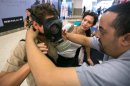 An Israeli man tries on a gas mask at a distribution point in the West Bank, near Jerusalem, on Aug. 26.