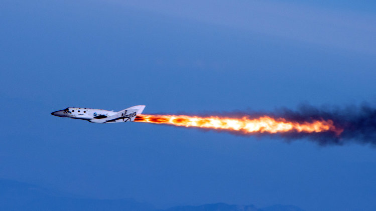 FILE - In this April 29, 2013 photo provided by Virgin Galactic, the company's SpaceShipTwo fires its rockets over Mojave, Calif. after it was dropped from its "mothership," WhiteKnightTwo. It is one of several new private ventures that involve taking people into outer space for a price, ventures that many hope will become as lucrative as they are revolutionary. And that prospect has California racing other states to woo new space companies with cushy incentives. (AP Photo/Virgin Galactic, Mark Greenberg, file)
