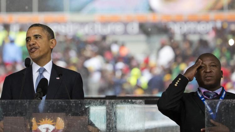 FILE - In this file photo from Dec.10, 2013, Thamsanqa Jantjie, right, interprets in sign language for President Barack Obama during his remarks at a memorial service at FNB Stadium in honor of Nelson Mandela in Soweto, near Johannesburg. The South African government says it is aware of reports that Jantjie faced a murder charge a decade ago, and says he is being investigated. (AP Photo/Evan Vucci, File)
