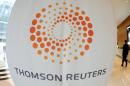 A man walks near a Thomson Reuters logo at the Thomson Reuters building in Canary Wharf in east London