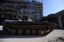 A member of Forces loyal to Syria's President Bashar al-Asaad is seen atop of an armoured vehicle in a government held area of Aleppo
