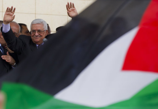 Palestinian President Mahmoud Abbas waves to supporters during his arrival at the government compound, in the West Bank city of Ramallah, Sunday, Sept. 25, 2011. Abbas has received a hero's welcome in the West Bank, triumphantly telling his people the 
