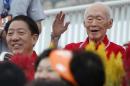 Former PM Lee waves to audience during Singapore's 49th National Day Parade at floating platform in Marina Bay