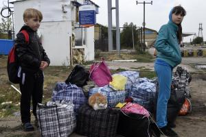 Children wait with their belongings after crossing&nbsp;&hellip;