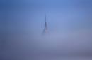 AP10ThingsToSee - The tip of the Empire State Building in New York peeks through thick fog in this view from Hoboken, N.J. on Wednesday, Jan. 15, 2014. (AP Photo/Julio Cortez, File)