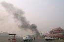 Police cars block off the roads leading into Tiananmen Square as smoke rises into the air after a vehicle crashed in front of Tiananmen Gate in Beijing on October 28, 2013
