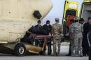 Egyptian paramedics load the corpses of victims of a Russian passenger plane crash in the Sinai Peninsula, into a military plane at Kabret military air base on October 31, 2015