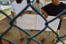 ADDS TO CLARIFY THAT THE MEN PICTURED WERE RESETTLED AT AN UNKNOWN DATE - FILE - In this June 1, 2009 file photo reviewed by the U.S. military, Chinese Uighur Guantanamo detainees, who at the time were cleared for release but had no country to go to, show a home-made note to visiting members of the media, at Camp Iguana detention facility, at Guantanamo Bay U.S. Naval Base, Cuba. Officials said on Tuesday Dec. 31, 2013, that Slovakia has accepted the last three Chinese Uighur prisoners from Guantanamo Bay who had posed a difficult resettlement challenge. Authorities eventually determined that the 22 Uighurs in its custody had no involvement in terrorism. The men in this photo were resettled at an unknown date. (AP Photo/Brennan Linsley, Pool, File)