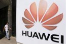 A man walks past a Huawei company logo outside the entrance of a Huawei office in Wuhan