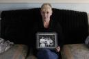 FILE- In this Thursday, Jan. 12, 2012 file photo, Helen McKendry holds a family photograph showing her mother Jean McConville at home in Killyleagh, Northern Ireland. Northern Ireland police say they have charged a 77-year-old man with involvement in the Irish Republican Army's 1972 abduction, killing and secret burial of a Belfast woman, an unsolved case linked to Sinn Fein leader Gerry Adams. The man was scheduled to be arraigned Saturday on charges of IRA membership and aiding the killers of Jean McConville, a widowed mother of 10. The IRA accused the 38-year-old of spying for British forces, abducted her at gunpoint from her home, and shot her in the back of the head. The IRA admitted responsibility in 1999. Her unmarked grave was discovered four years later in the Republic of Ireland. Two former IRA members since have accused Adams, a senior Belfast IRA figure in 1972, of ordering McConville's execution. Adams denies any involvement. (AP Photo/Peter Morrison, file)
