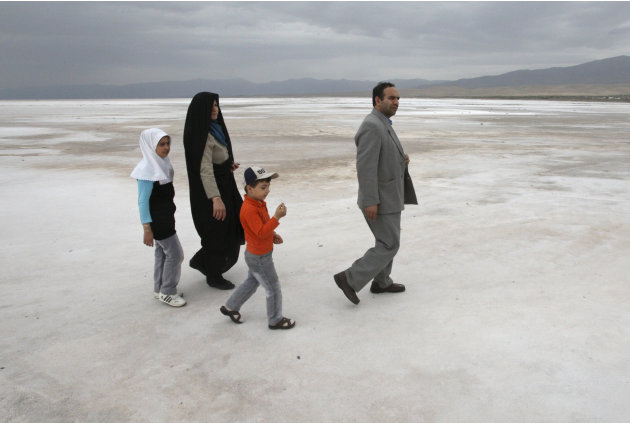 An Iranian family walk on the solidified salts of the Oroumieh Lake, as they sightsee the lake, some 370 miles (600 kilometers) northwest of the capital Tehran, Iran, Friday, April 29, 2011. (AP Photo