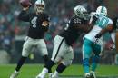 Oakland Raiders' Derek Carr, left, passes the ball during the NFL football game against Miami Dolphins at Wembley Stadium in London, Sunday, Sept. 28, 2014. (AP Photo/Tim Ireland)