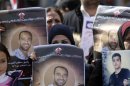 Palestinians hold placards depicting prisoner Samer al-Issawi during a protest in Ramallah