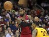 Miami Heat's James passes the ball past Cleveland Cavaliers defender Gee during their NBA basketball game in Cleveland