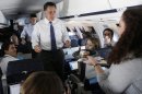 Ginger Gibson, national political reporter for Politico, right, offers two pieces of her birthday cake to Republican presidential candidate, former Massachusetts Gov. Mitt Romney as they fly to Long Island, NY, Thursday, Sept. 13, 2012. (AP Photo/Charles Dharapak)