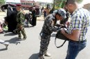 Iraqi police search the bags of Muslim Shiite pilgrims