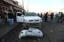 FILE - In this Monday, Dec. 28, 2015, file photo, Afghan security forces inspect the site of a suicide car bomb attack near the Kabul airport in Kabul, Afghanistan. Afghan forces are struggling to man the front lines against a resurgent Taliban, in part because of untold numbers of 