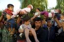 Migrants lift their children during protest in Edirne