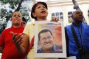 A supporter of Venezuelan President Chavez holds a picture of him, as she attends a ceremony to pray for his health in Caracas