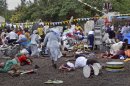 Wounded churchgoers lie on the ground as Roman Catholic nuns run for cover after a blast at the St. Joseph Mfanyakazi Roman Catholic Church in Arusha, Tanzania Sunday, May 5, 2013. A Tanzanian police official says a woman died and over 40 people were seriously injured when a bomb exploded in the Roman Catholic Church in northern Tanzania, with eyewitnesses reporting that the bomb was thrown from a motorcycle. (AP Photo)
