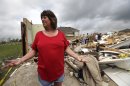 Sherry Enochs, stands in what is left of her home as she recounts the tornado that struck her home Wednesday, April 4, 2012, in Forney, Texas. Enochs was babysitting three children all under the age of 3, when the tornado struck. All survived the storm with minor bumps and bruises. (AP Photo/Tony Gutierrez)