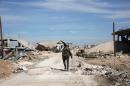 A pro-government fighter walks down a road in the Syrian town of Arbid on the outskirts of Kweyris military airbase, in the northern province of Aleppo, on November 12, 2015