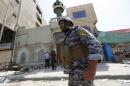 A member of the Iraqi security forces stands guard outside a Shi'ite mosque after a bomb attack in Baghdad